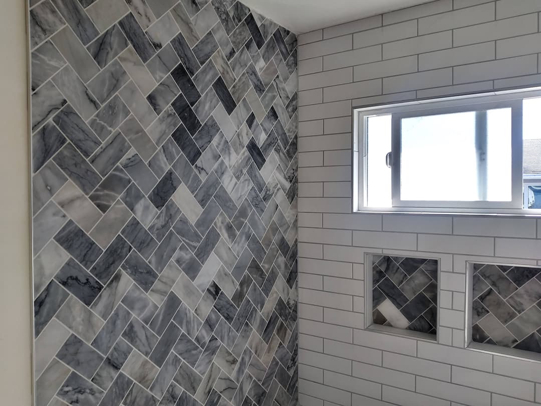 remodeled bathroom wall with custom luxury tiling in a zigzag pattern