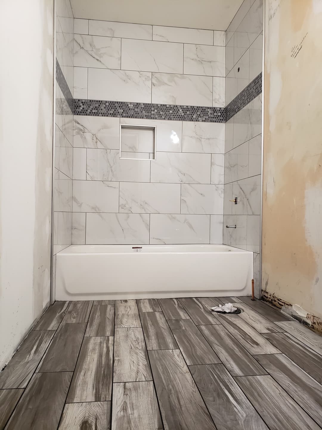 remodeling a custom white tile bathroom and tub and shower and laminate grey flooring