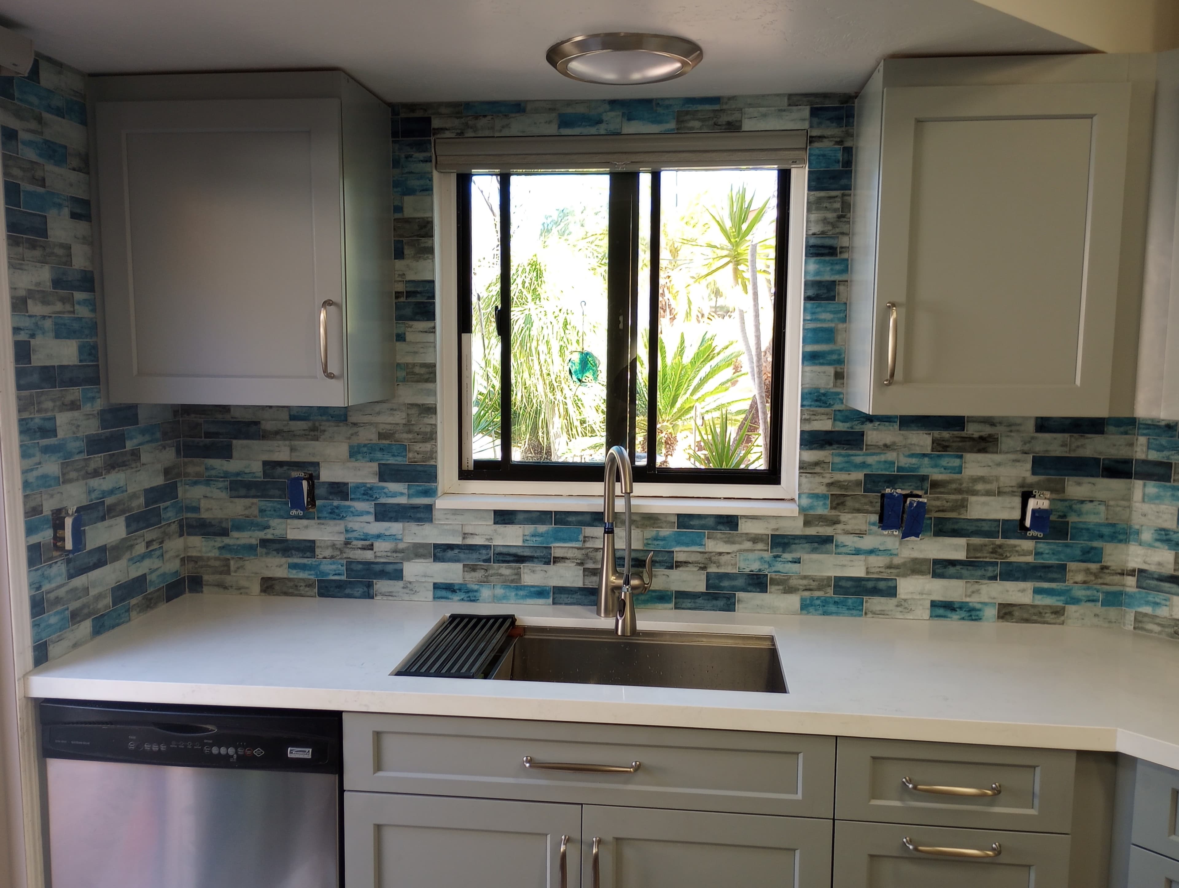 New remodeled kitchen with brand new cabinets countertops and blue and white granite tile backsplash 